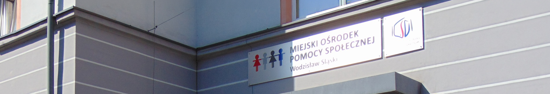 Baner wizerunkowy top Miejskiego Ośrodka Pomocy SPołecznej w Wodzislawiu Śląskim, zdjęcie banera z nazwą ośrodka wiszącego nad wejściem do budynku